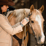 womens western business jacket with native American made rings.  Adjusting headstall on palomino mare.