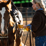 Saddling cow horse with chore gloves and a sherpa hoodie.  Ariat Denim.